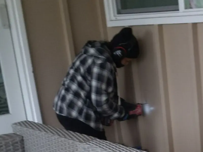 Professional electrician installing an exterior outlet in Russell